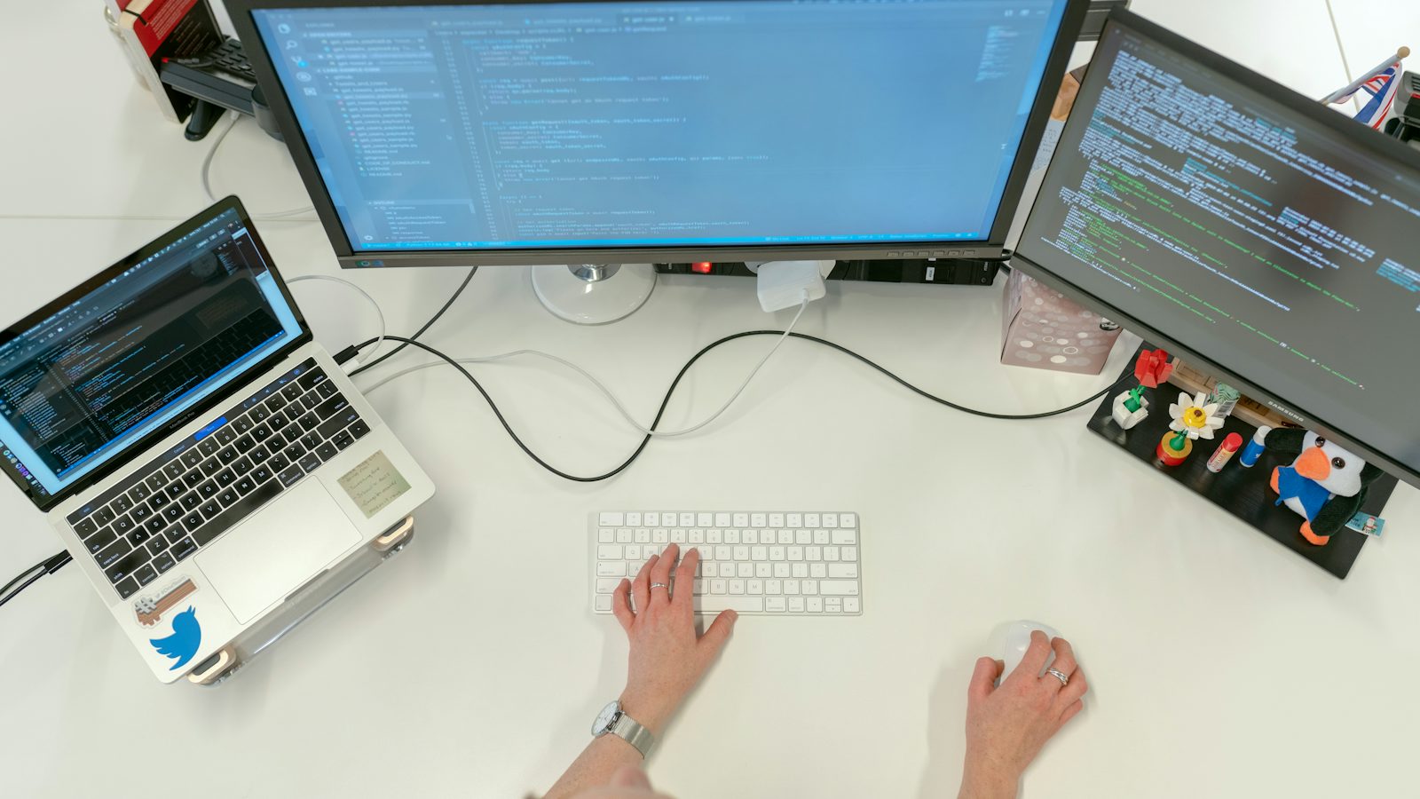 Desk with multiple monitors of code representing AI and business automation in Monterey