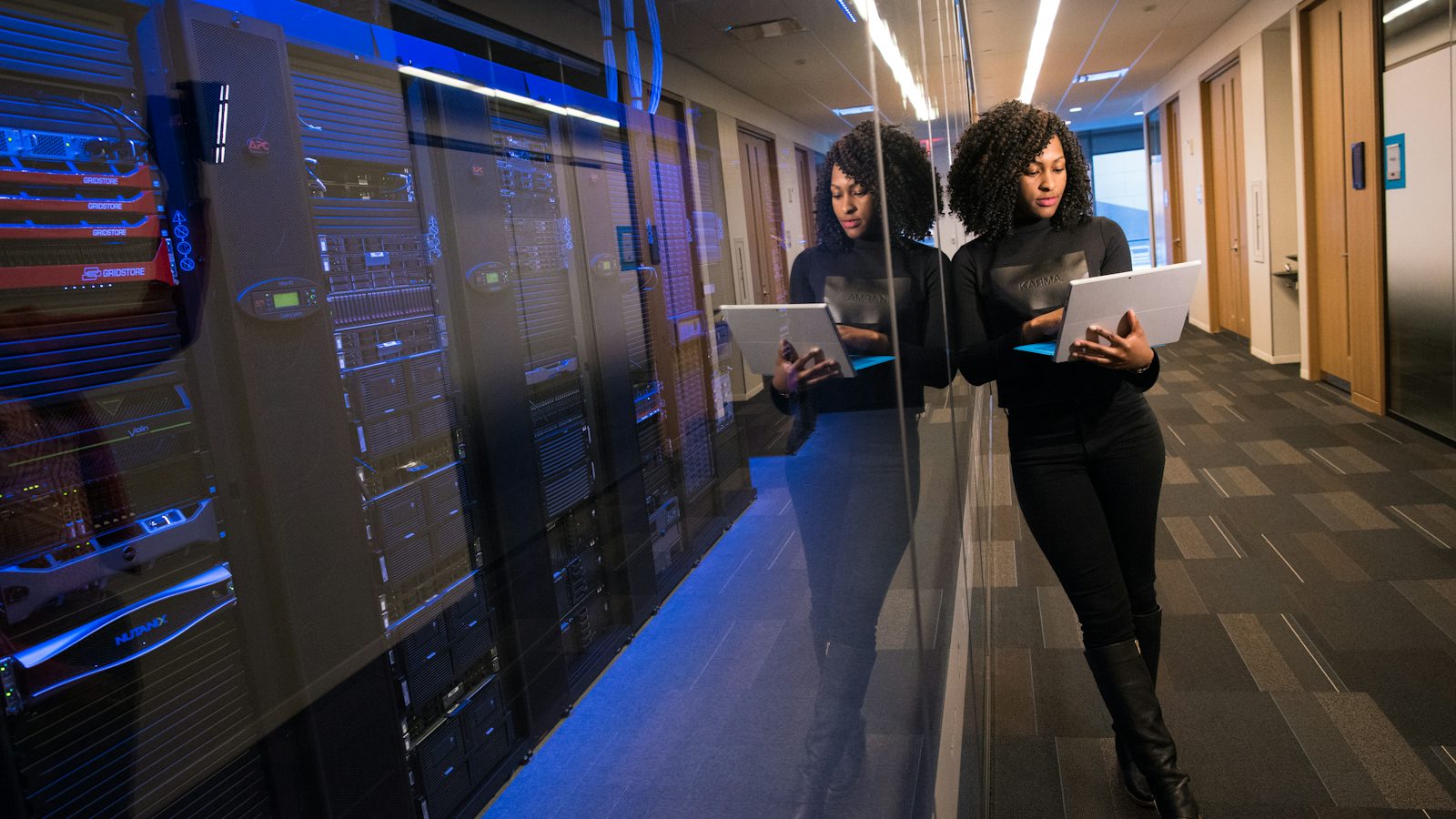 Two IT staff with laptops in a server room, representing co-managed IT in Monterey