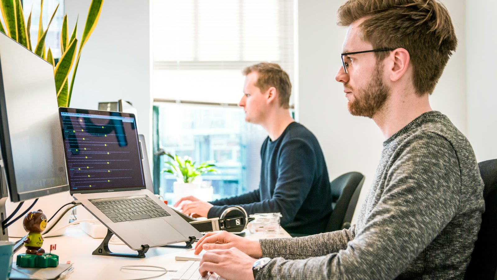 Two people working at monitors, showing managed IT services for Monterey offices