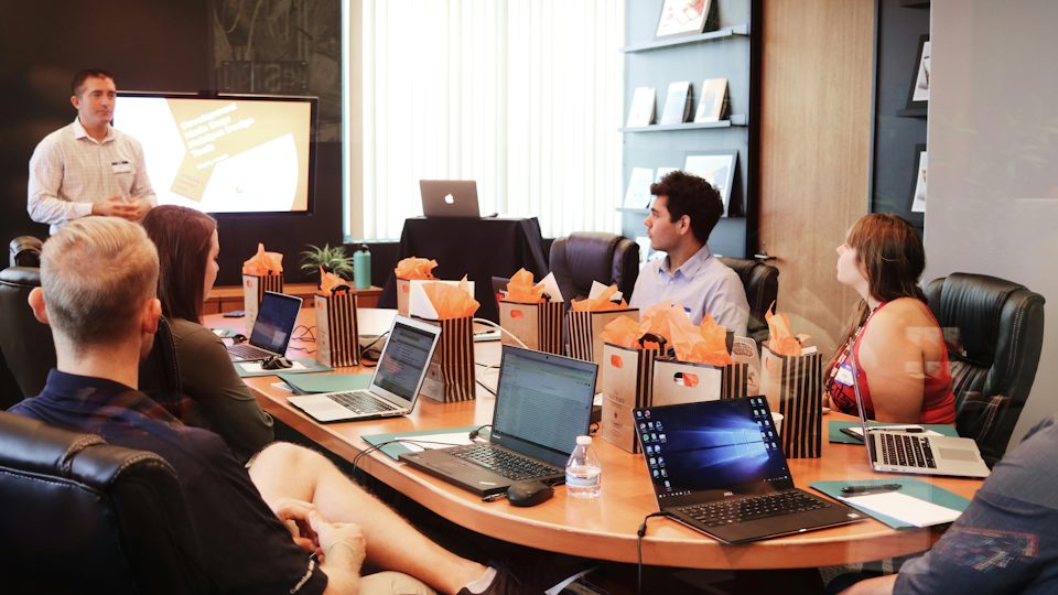 Rayne Technology Solutions team meeting with laptops around a conference table